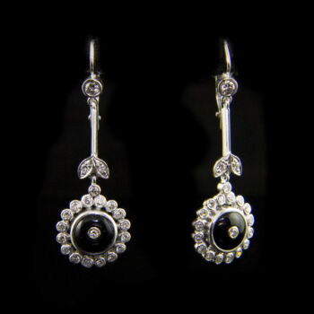 A pair of dangling earrings with onyx stones in a daisy shape